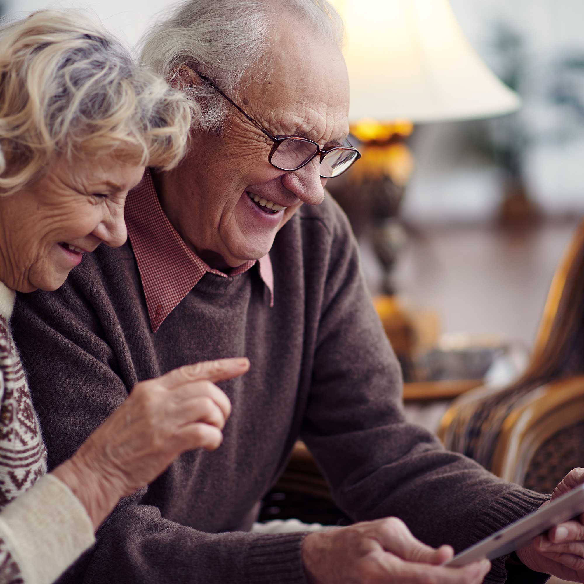 Elderly husband and wife using digital tablet at home